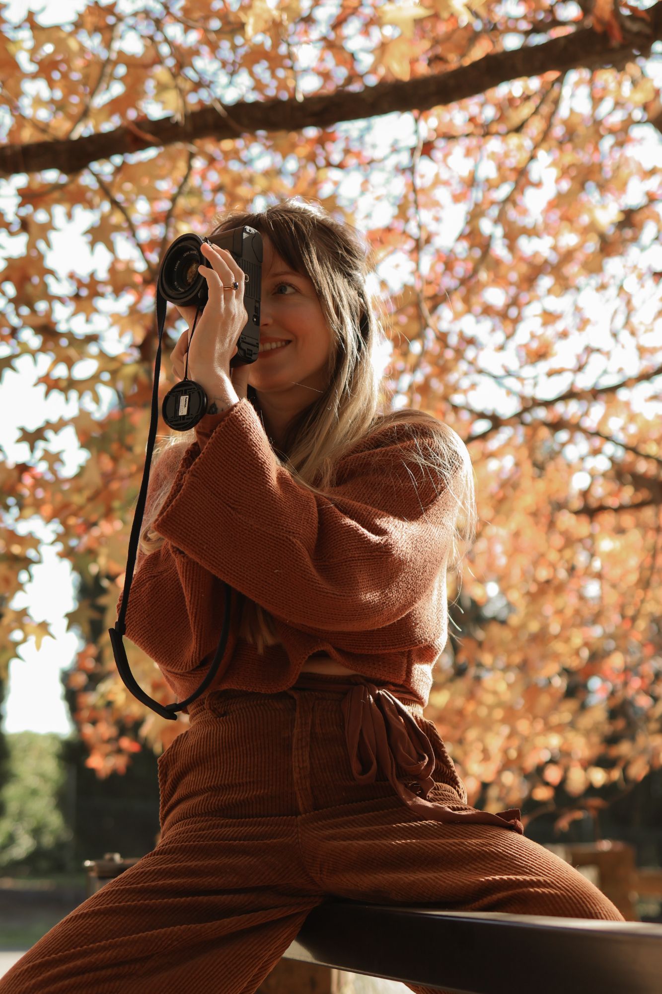Louisa photographing beneath autumn leaves