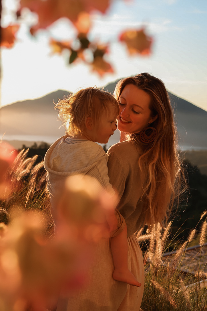 Louisa holding her son at sunset