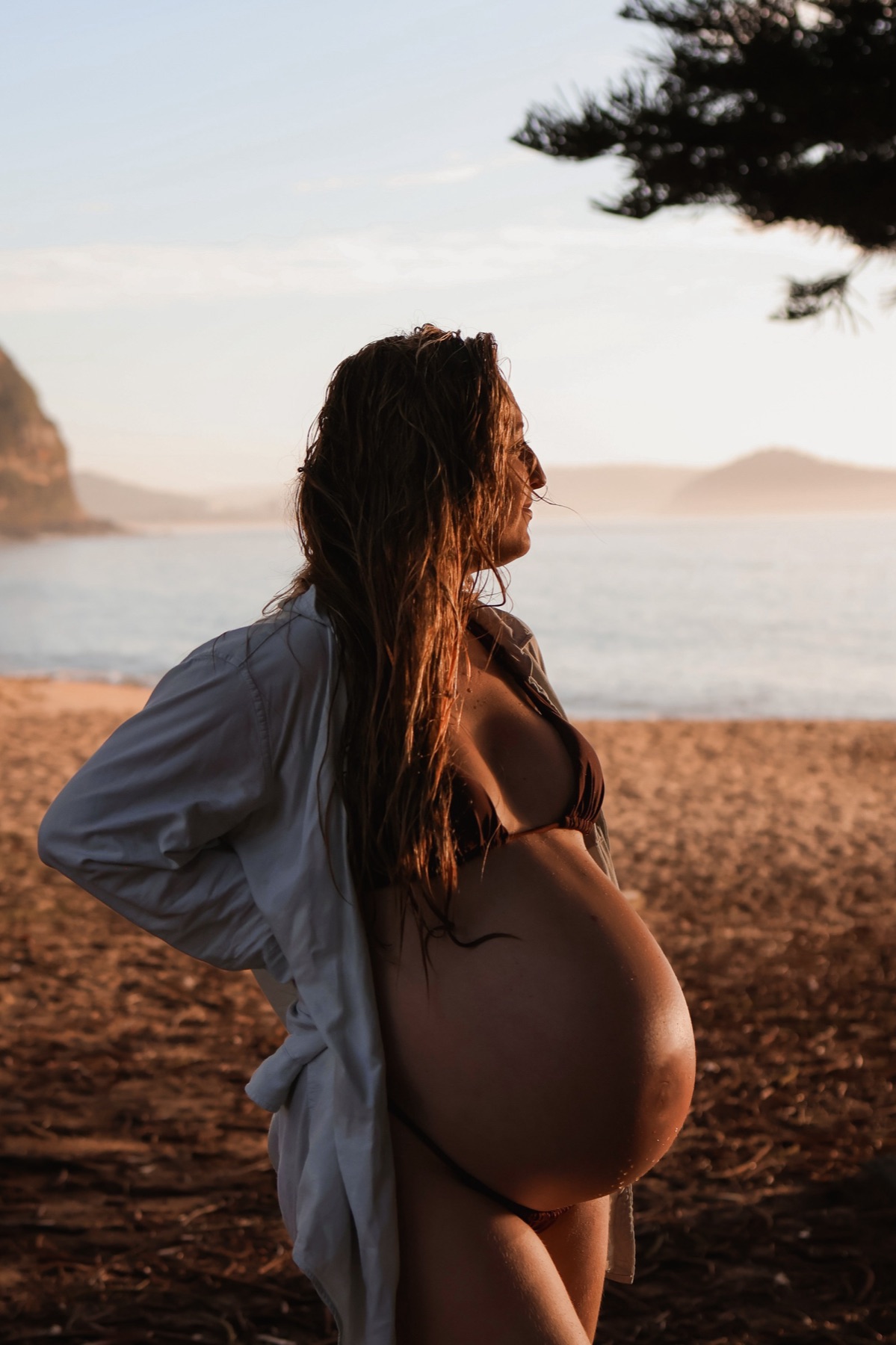 Maternity portrait on a rocky beach at golden hour