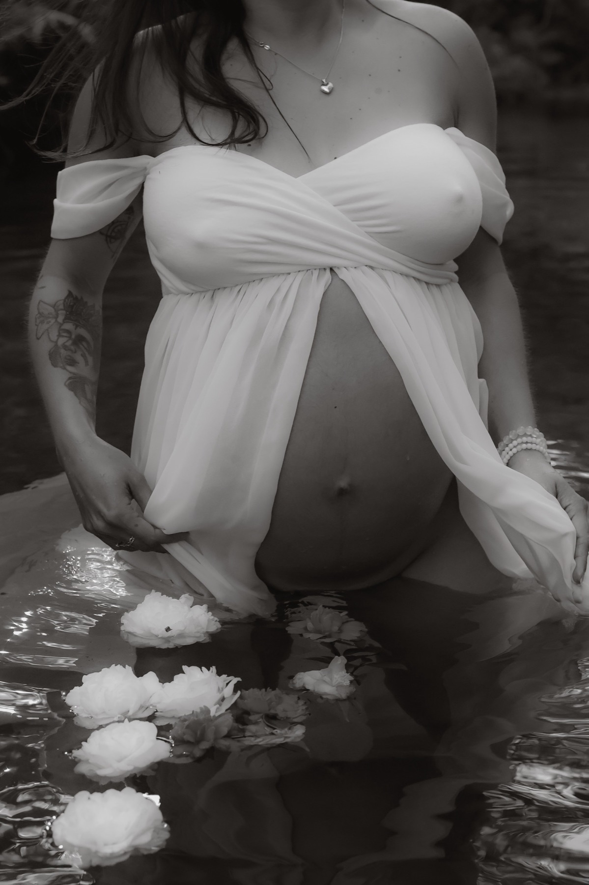 Black and white maternity portrait among white flowers